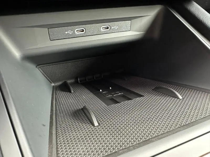 Gros plan sur la zone de recharge avec deux ports USB-C intégrés dans l’espace de rangement noir du CUPRA Formentor gris Graphène.
