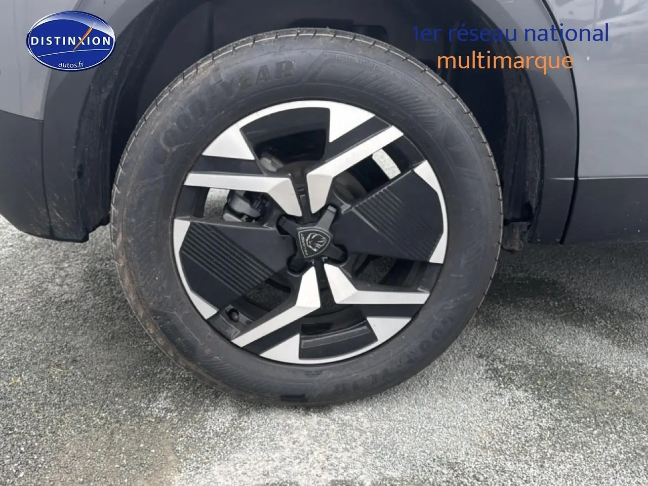 Gros plan sur la roue avant droite du Peugeot 2008 gris sélénite avec jante alu au design moderne.