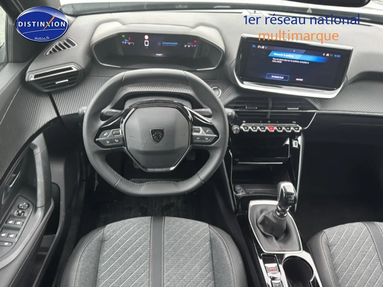 Vue intérieure frontale du poste de conduite du Peugeot 2008 gris sélénite avec volant multifonction et écran tactile central.