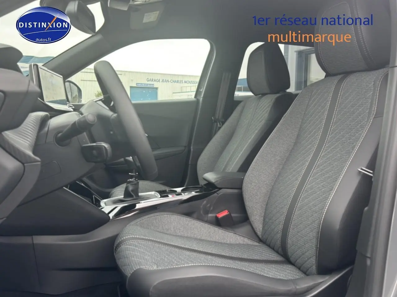 Vue intérieure côté conducteur du Peugeot 2008 1.2 100 allure 2025 avec sièges tissu gris casual lomsa embossé et volant multifonction.