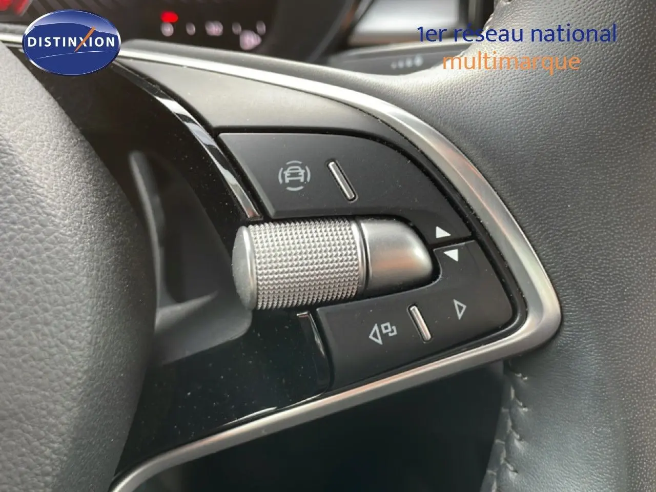 Gros plan sur les commandes multifonctions en métal brossé du volant d’une Skoda Fabia blanche Glacier 2025.