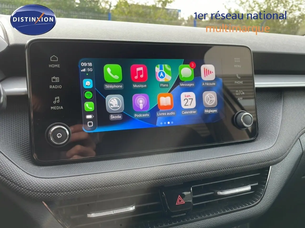 Écran tactile central allumé dans l’habitacle gris-noir d’une Skoda Fabia blanche Glacier 2025, vue de face.