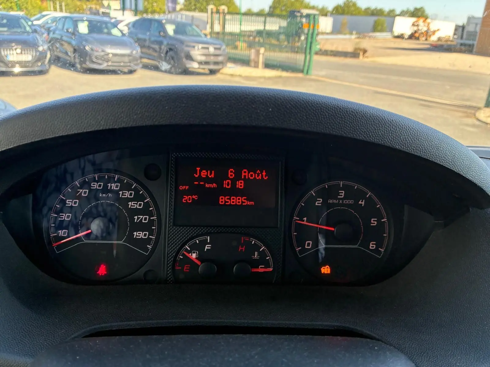 Vue rapprochée du tableau de bord du Peugeot Boxer cabine approfondie gris, affichant compteur et écran digital rouge.