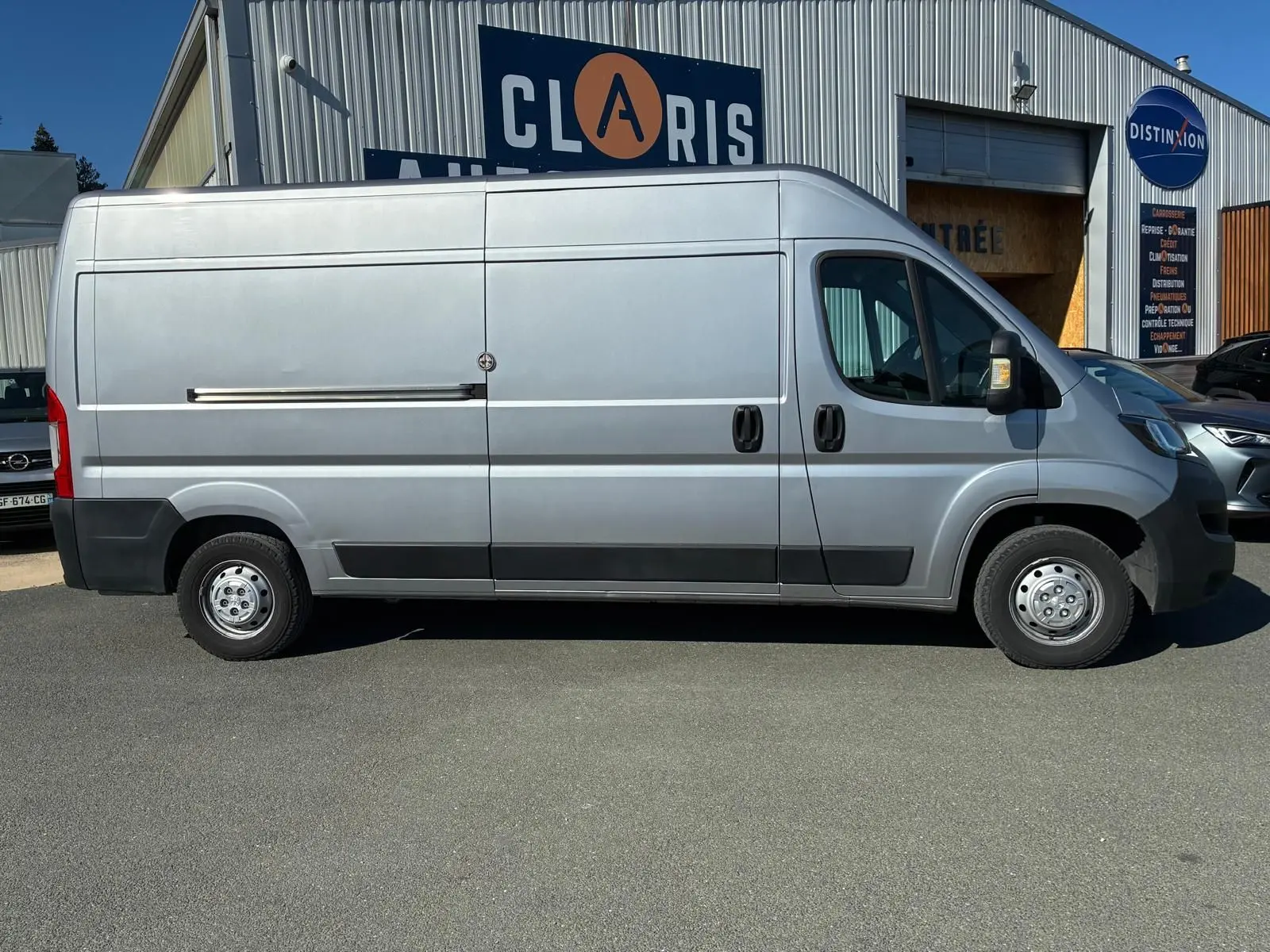 Vue de profil côté droit d’un Peugeot Boxer cabine approfondie gris 2019, avec porte latérale coulissante et jantes acier.