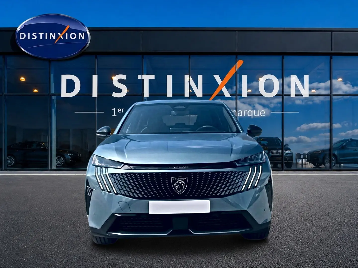 Vue avant d'un Peugeot 3008 bleu 2025 avec calandre noire distinctive et phares LED verticaux, devant une vitrine Distinxion.