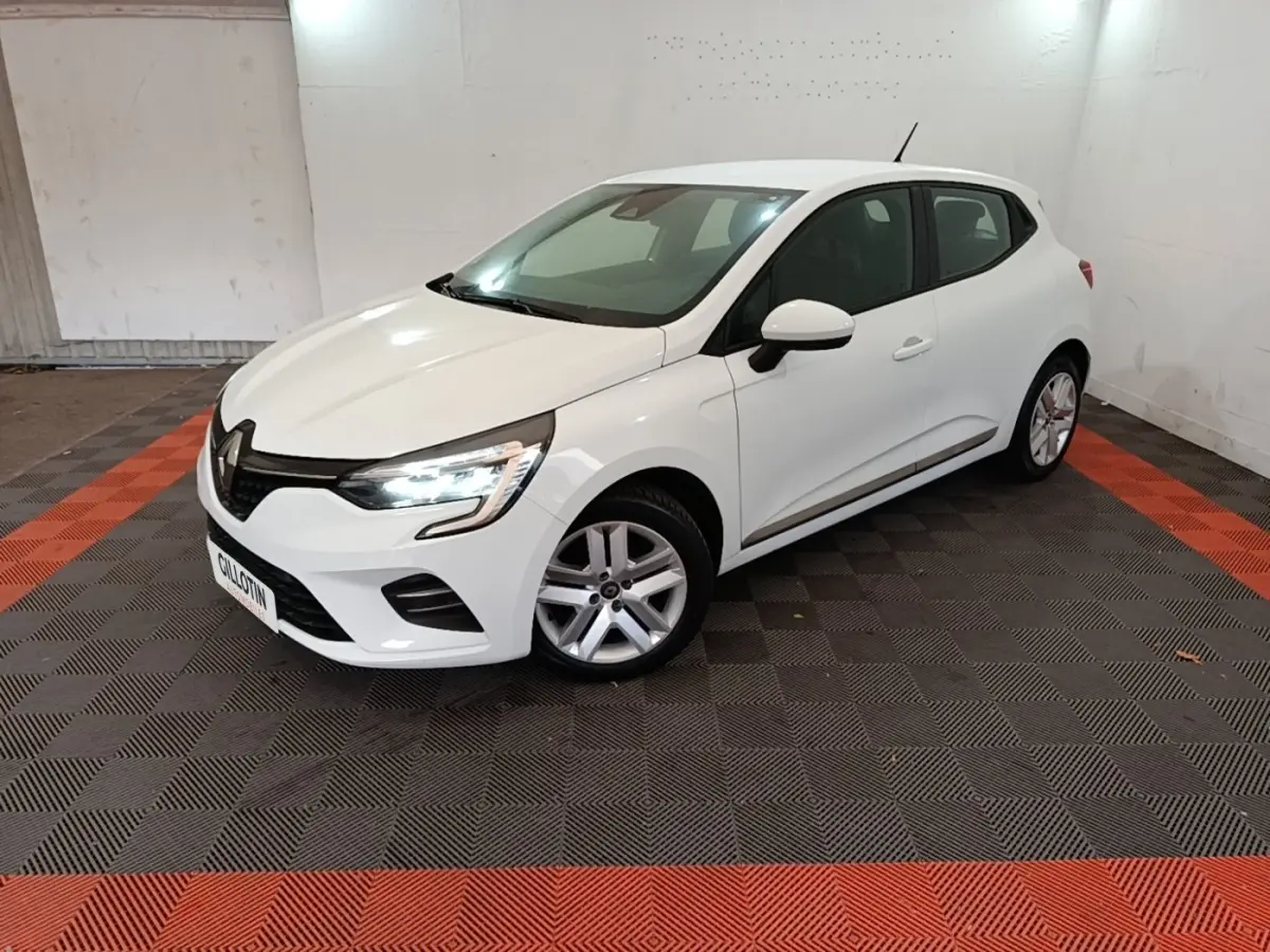 Renault Clio Business TCe 90 blanche vue 3/4 avant droit, avec feux LED allumés dans un garage.