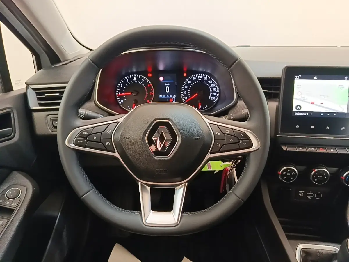 Vue intérieure centrée sur le volant cuir multifonctions de la Renault Clio Business TCe 90 avec tableau de bord et écran tactile.