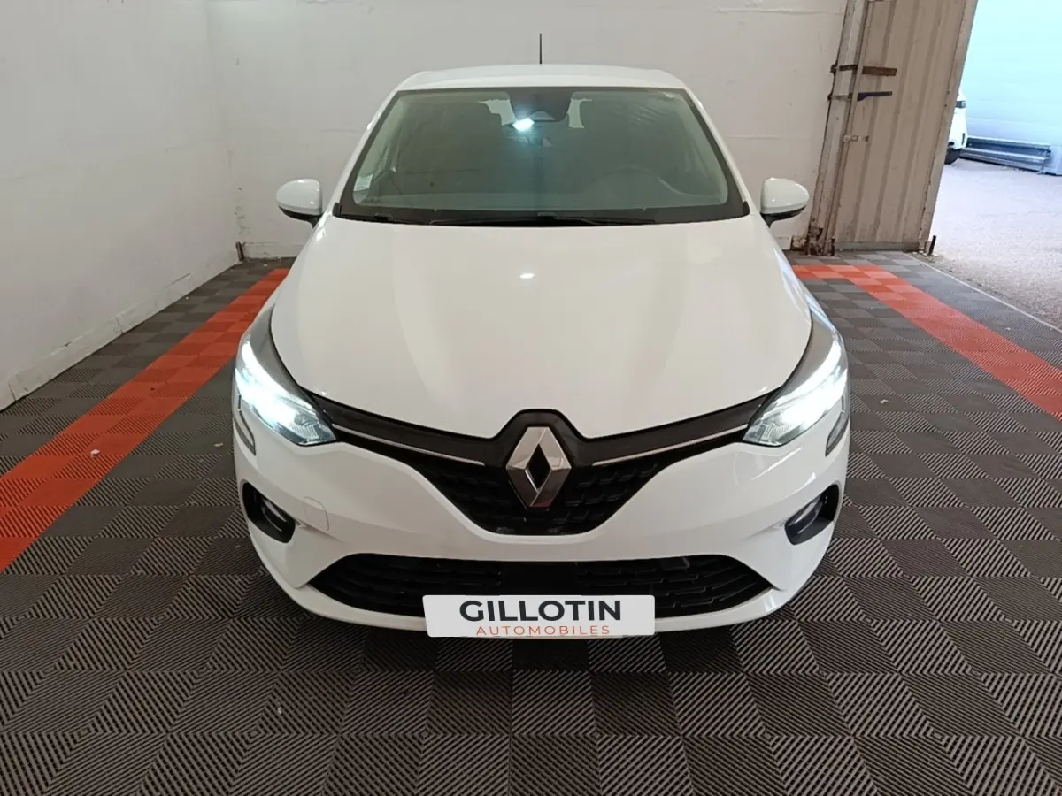 Vue avant d'une Renault Clio Business TCe 90 blanche avec phares LED allumés dans un garage.