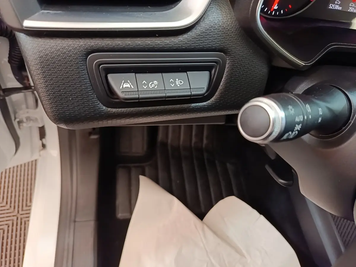Vue intérieure côté conducteur de la Renault Clio blanche 2020, avec commandes d'assistance au volant en cuir synthétique.
