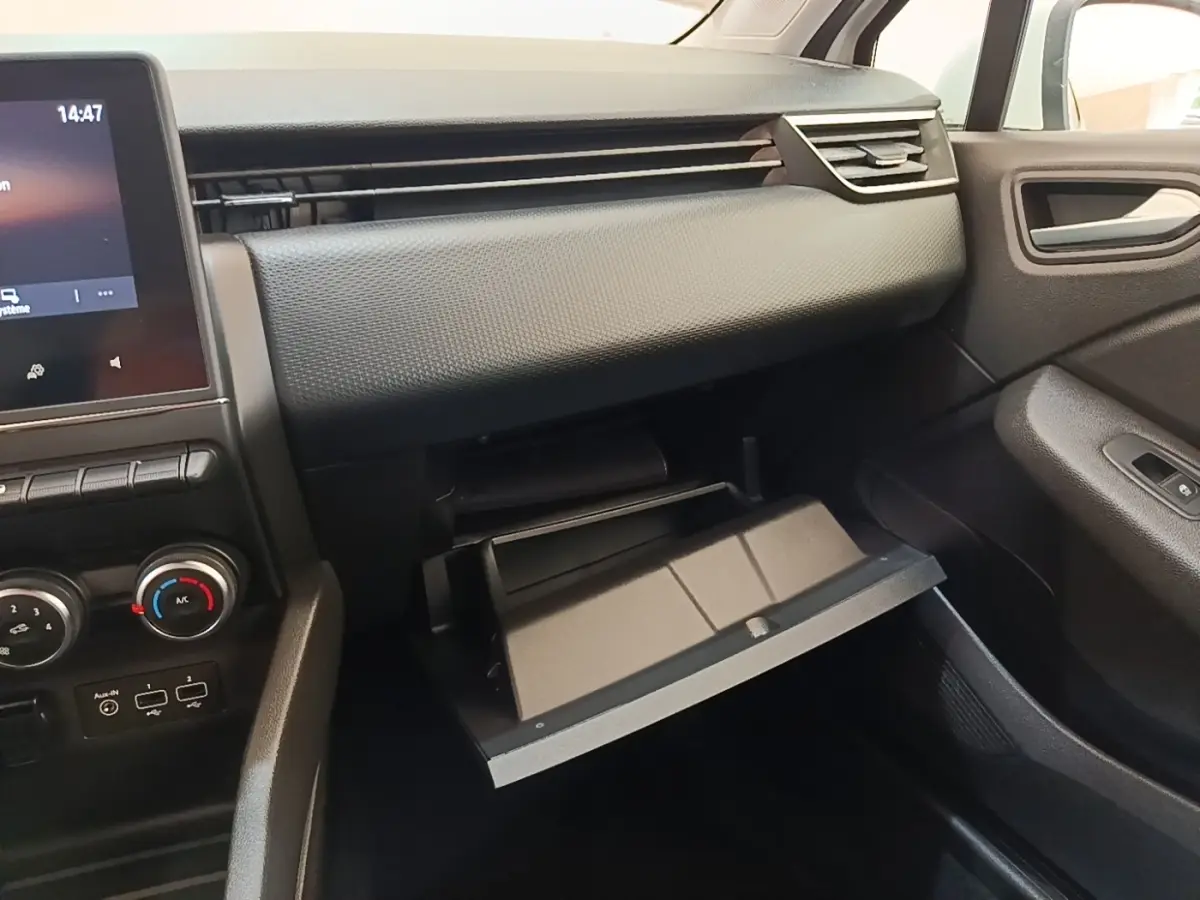 Intérieur Renault Clio Business TCe 90 2020, vue côté passager sur la boîte à gants ouverte et tableau de bord noir.