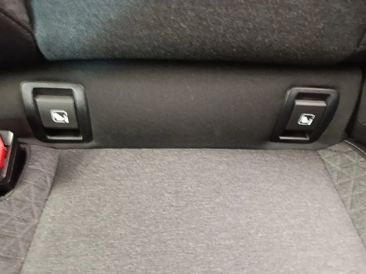 Gros plan sur la banquette arrière grise de la Renault Clio Business TCe 90 avec commandes de rabattement visibles.