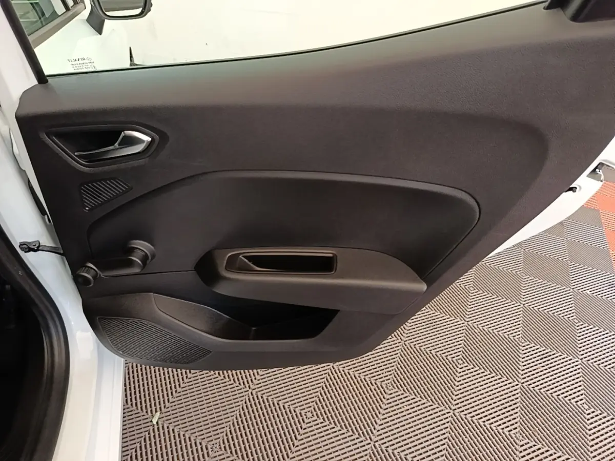 Porte avant gauche ouverte d’une Renault Clio blanche 2020, intérieur noir avec poignée manuelle de vitre.
