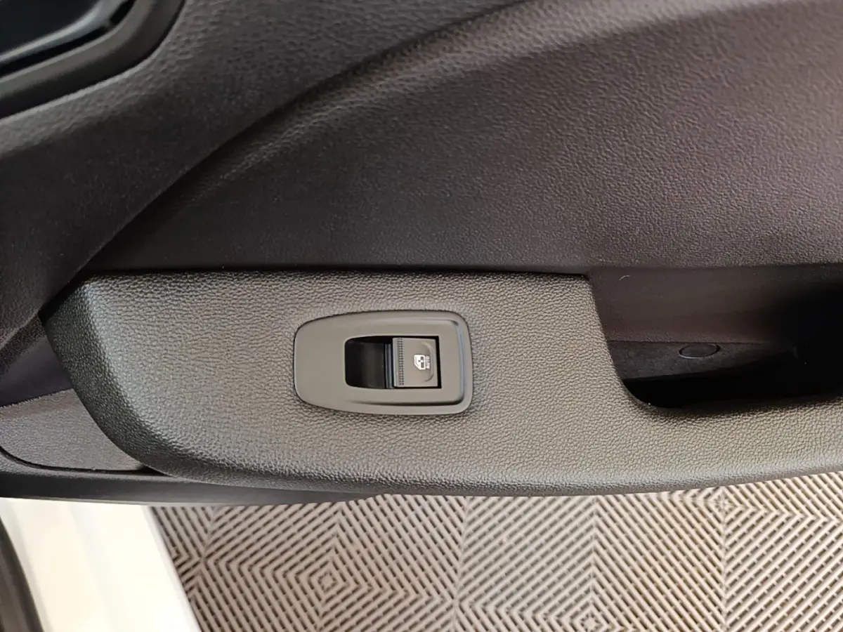 Gros plan sur l'interrupteur de verrouillage des portes côté intérieur d'une Renault Clio Business blanche.