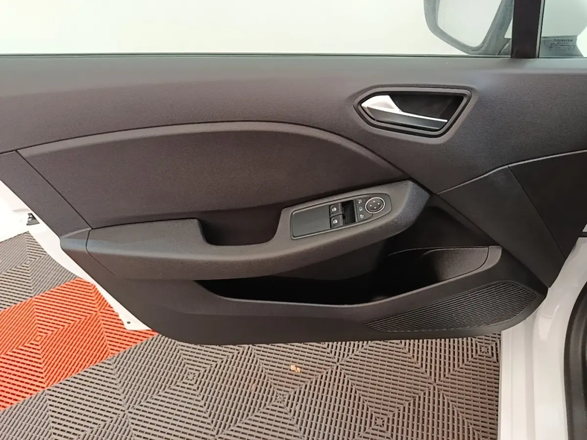Vue rapprochée de la porte avant gauche blanche de la Renault Clio 2020 avec commandes électriques des vitres et poignée intégrée.