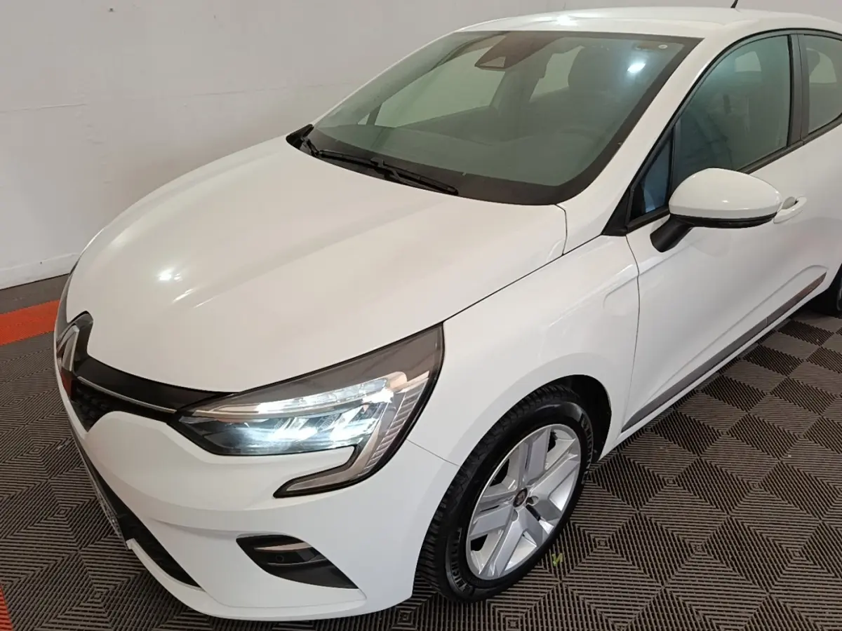 Renault Clio Business TCe 90 blanc vue 3/4 avant droit, avec phares LED allumés et jantes alliage.