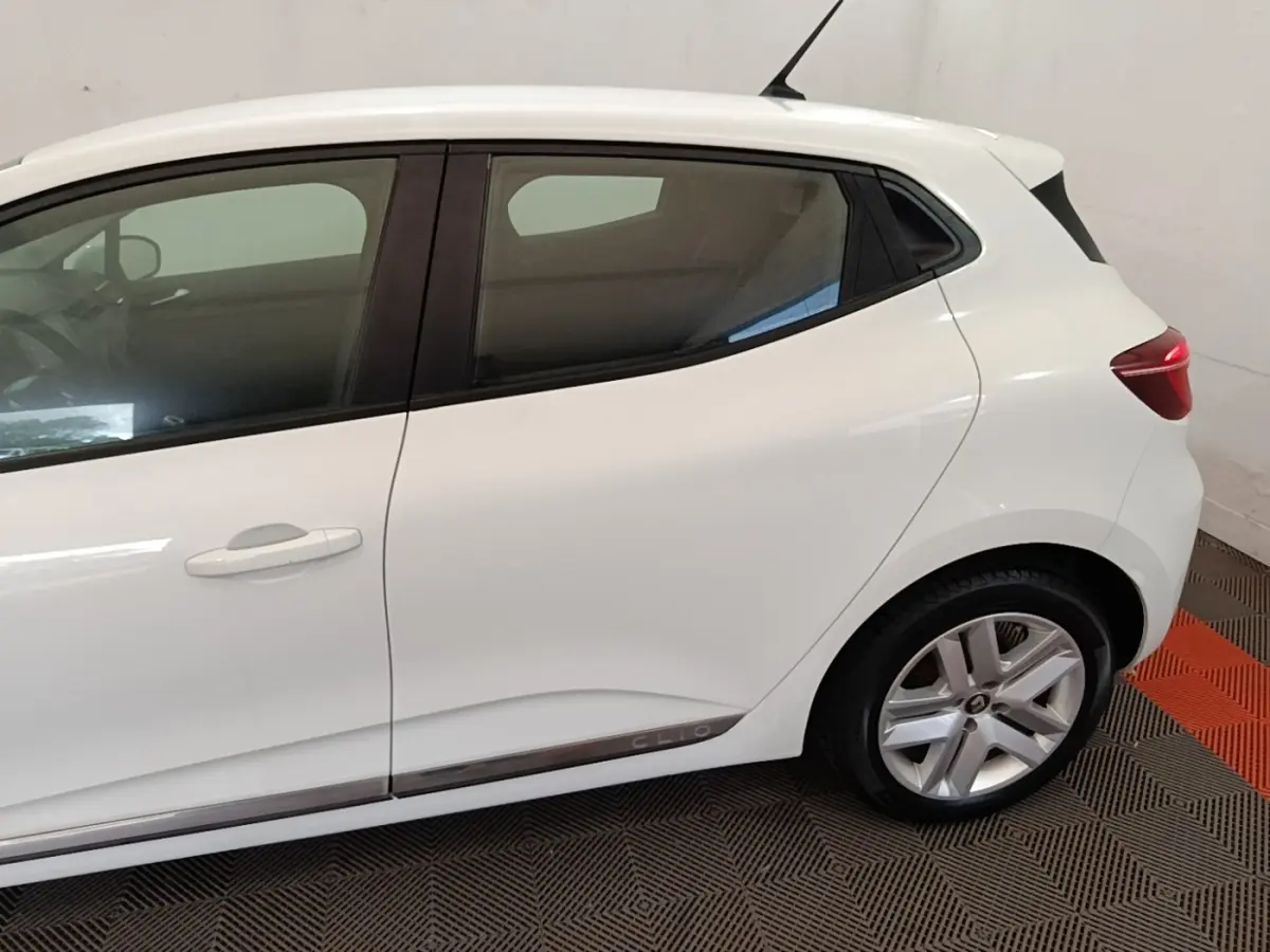 Vue latérale droite d'une Renault Clio blanche 2020 avec jantes alliage et logo Clio sur la bas de caisse.