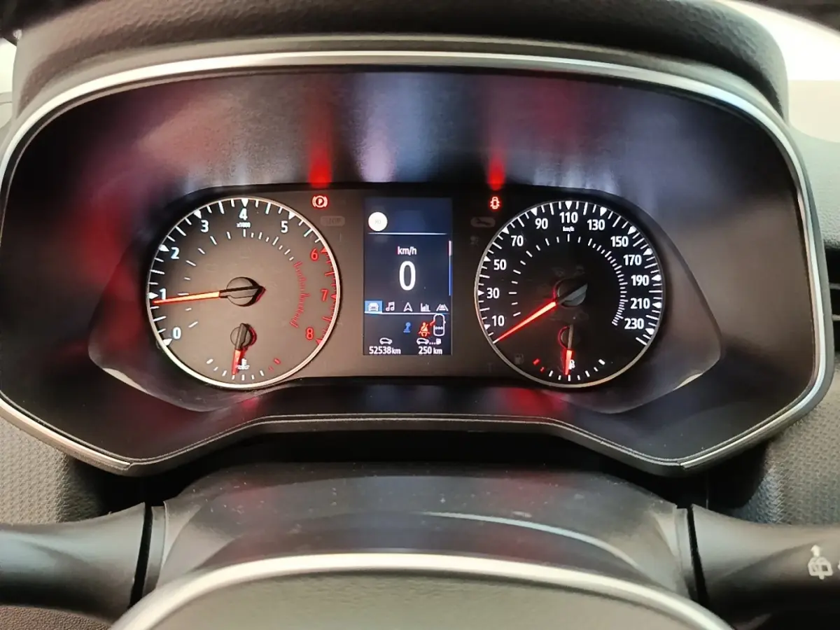 Vue rapprochée du tableau de bord de la Renault Clio blanche, affichant le compteur de vitesse et le compte-tours.