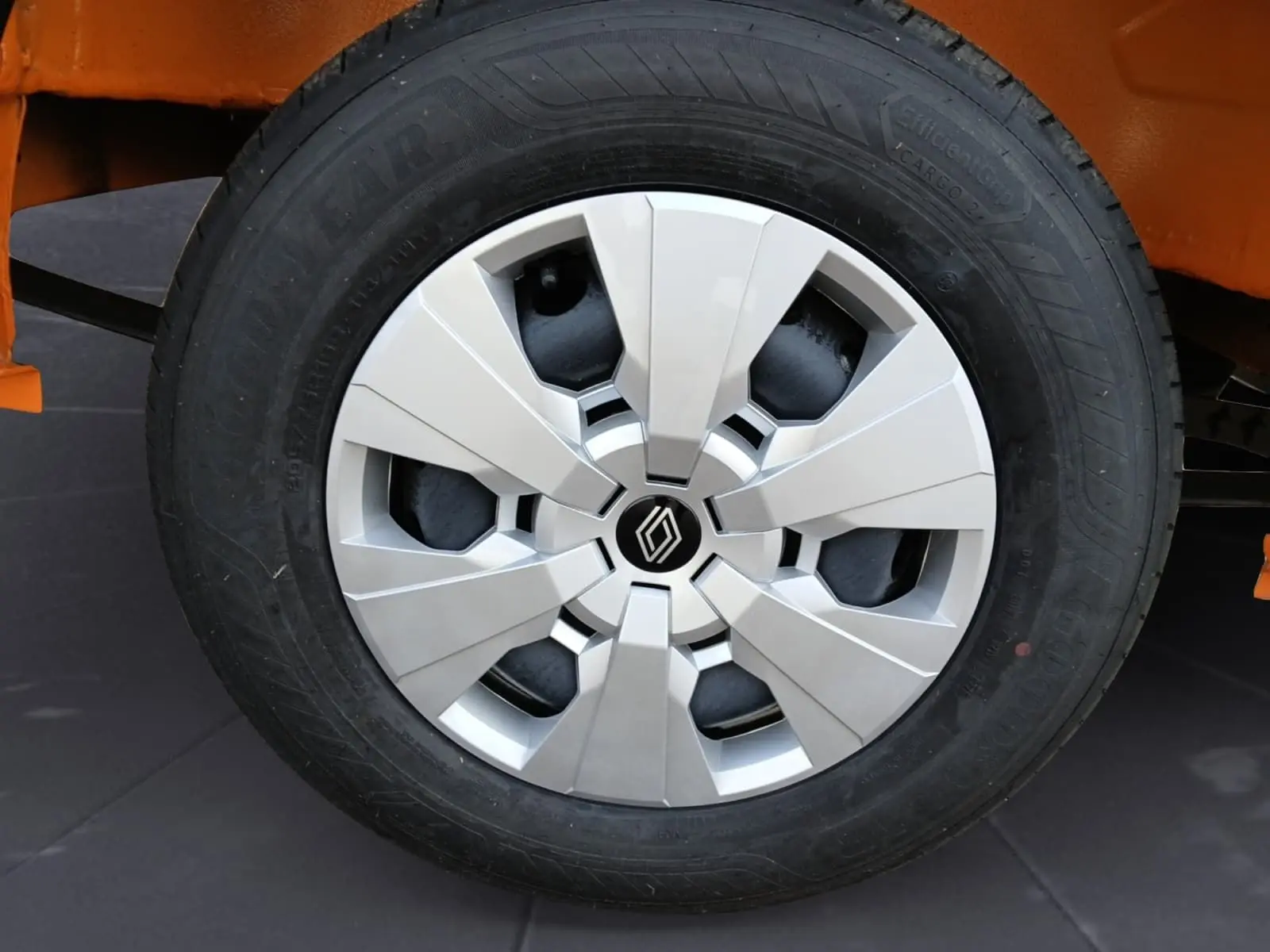 Gros plan sur la roue avant gauche du Renault Master orange, mettant en valeur la jante argentée au design moderne.