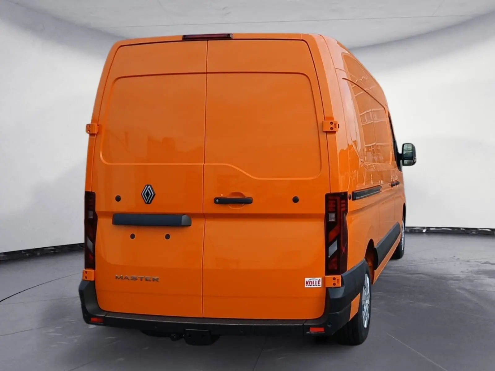 Vue arrière d’un Renault Master L2H2 orange 2026 avec hayon fermé et attelage visible sous le pare-chocs.