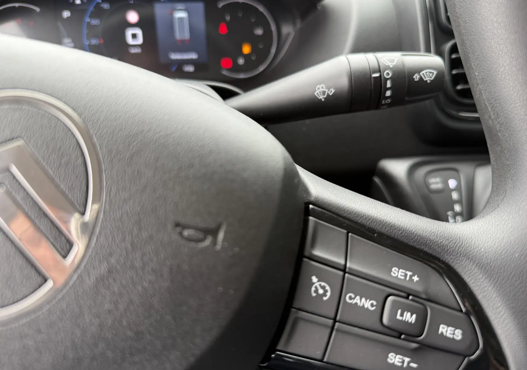 Gros plan sur le volant noir du Citroën Jumper 2025 avec commandes de régulateur et tableau de bord flou en arrière-plan.