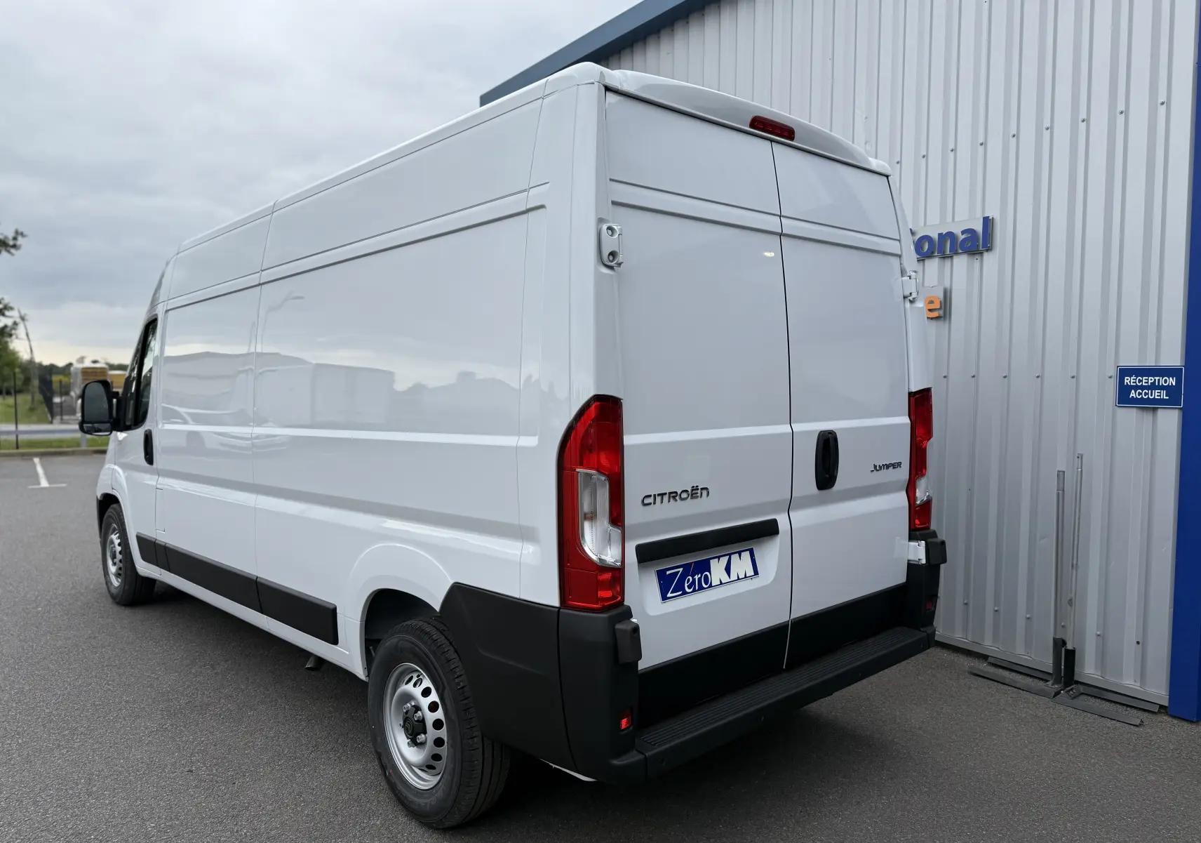 Vue 3/4 arrière droite d'un utilitaire Citroën Jumper blanc 2025 avec portes arrière battantes et pare-chocs noir.
