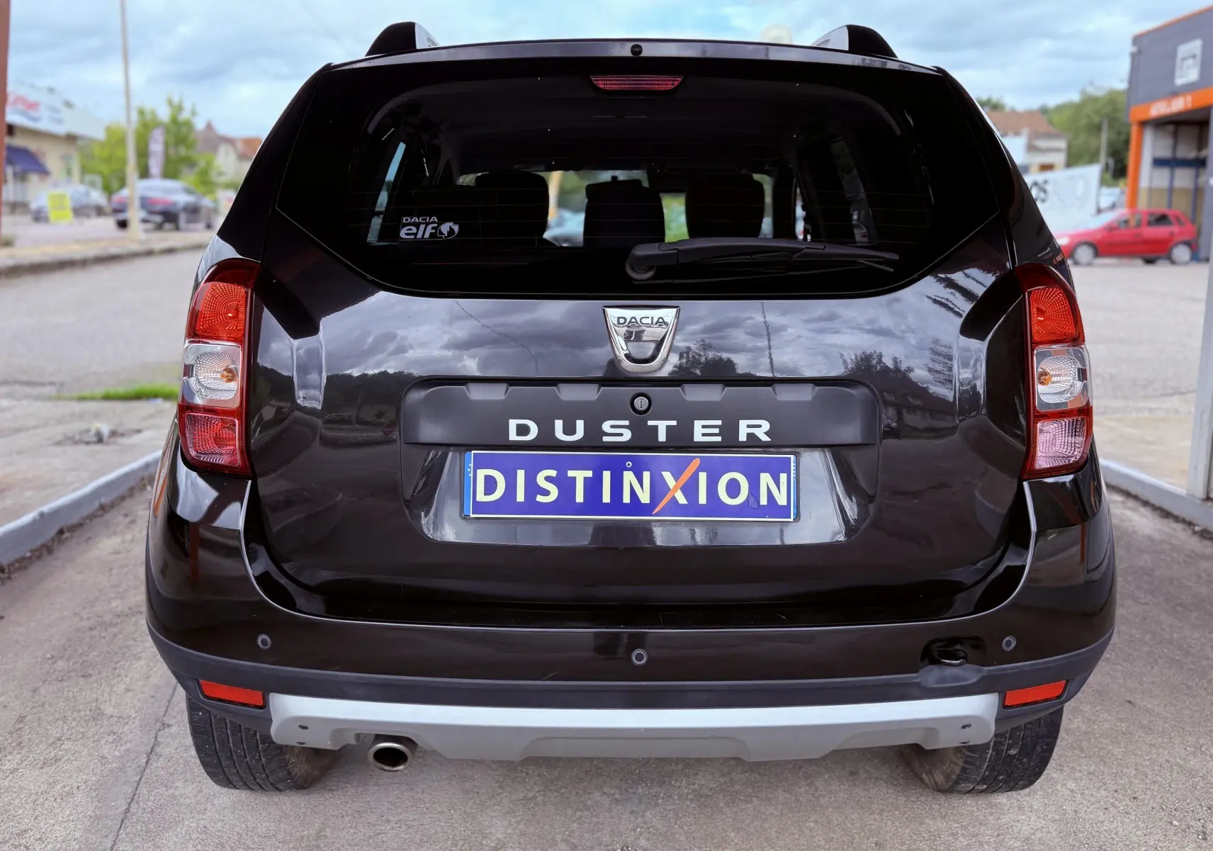 Vue arrière d'un Dacia Duster noir métal 2017 avec logo Dacia et plaque d'immatriculation personnalisée "DISTINXION".