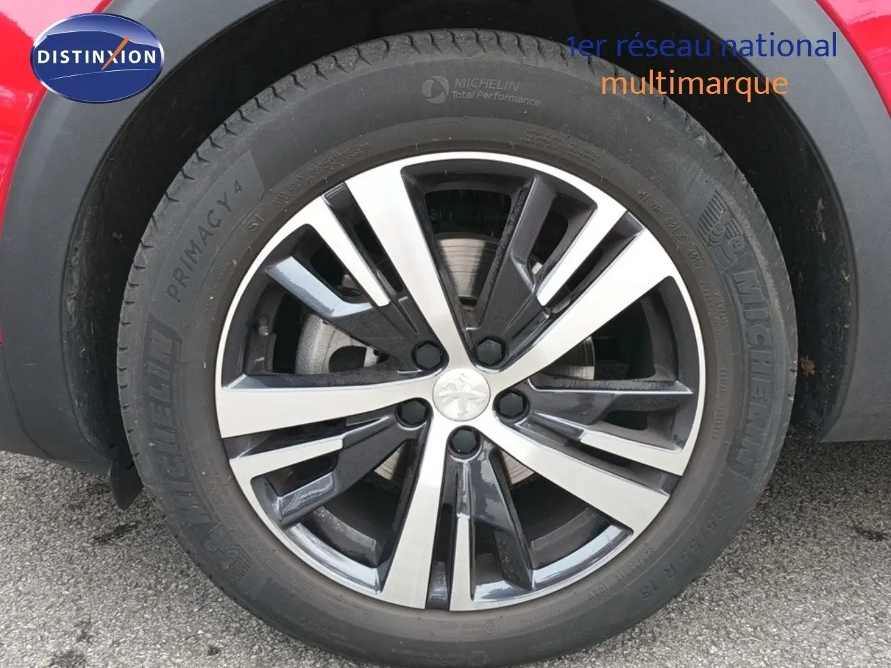 Gros plan sur la jante alliage bicolore du côté gauche d'un Peugeot 3008 rouge foncé métallisé de 2020.