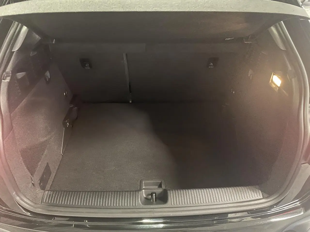 Coffre ouvert vu de face d’un Audi Q2 noir métallisé 2023, espace de chargement vide et éclairage intérieur allumé.