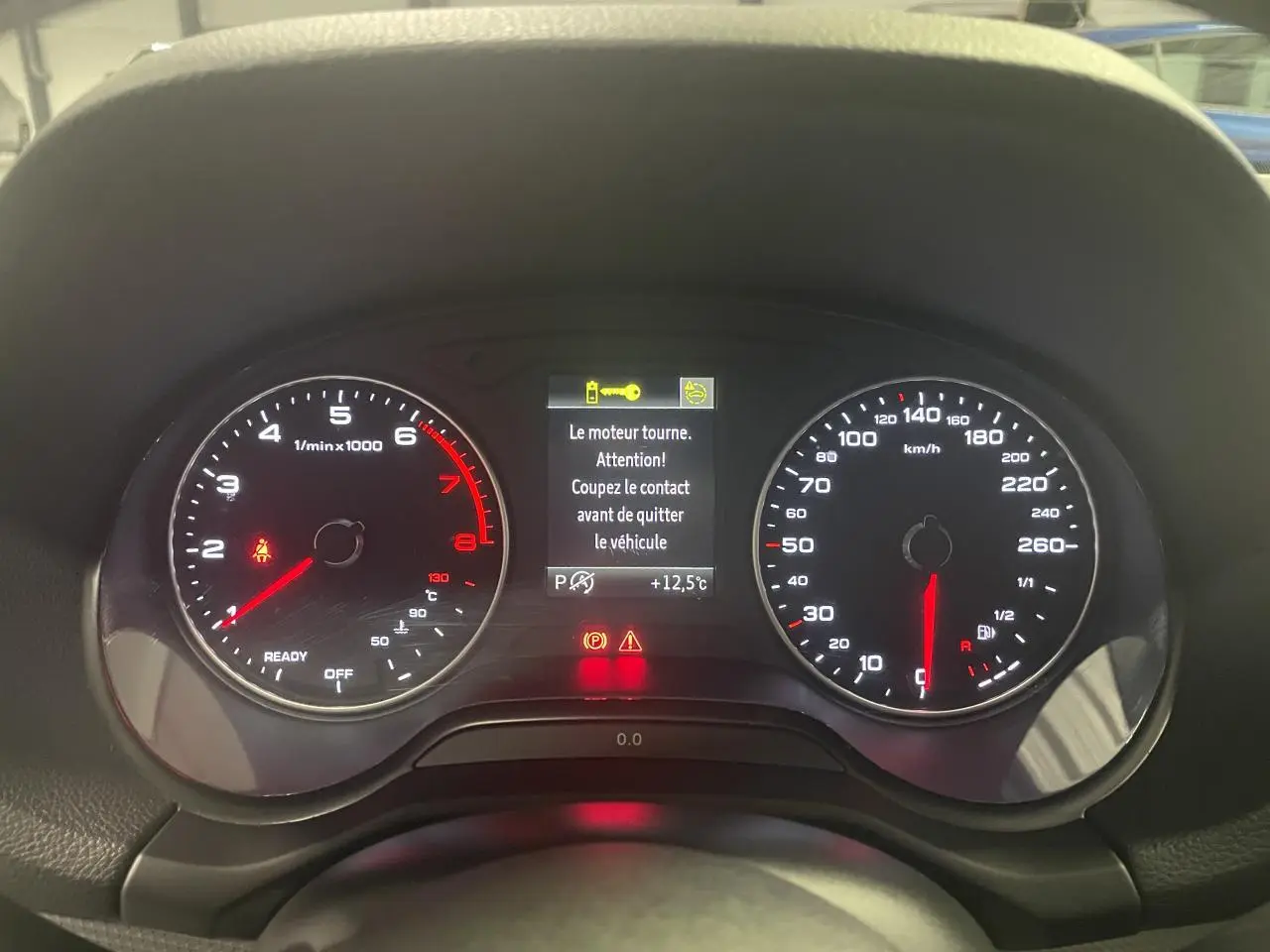 Vue rapprochée du tableau de bord numérique d’un Audi Q2 1.5 TFSI 2023, affichage moteur en marche.