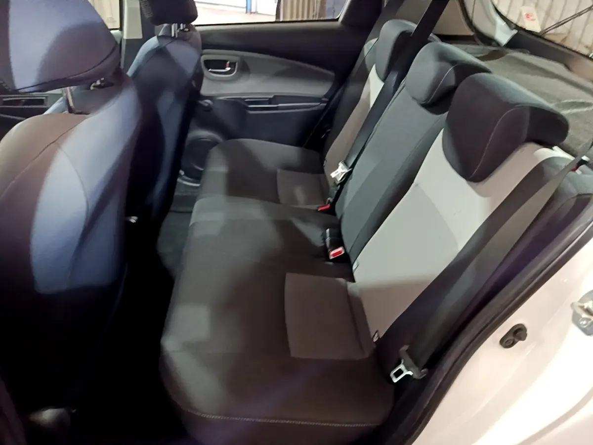 Vue intérieure côté droit montrant la banquette arrière noire et grise de la Toyota Yaris 1.5 Hybrid 2019 blanche.