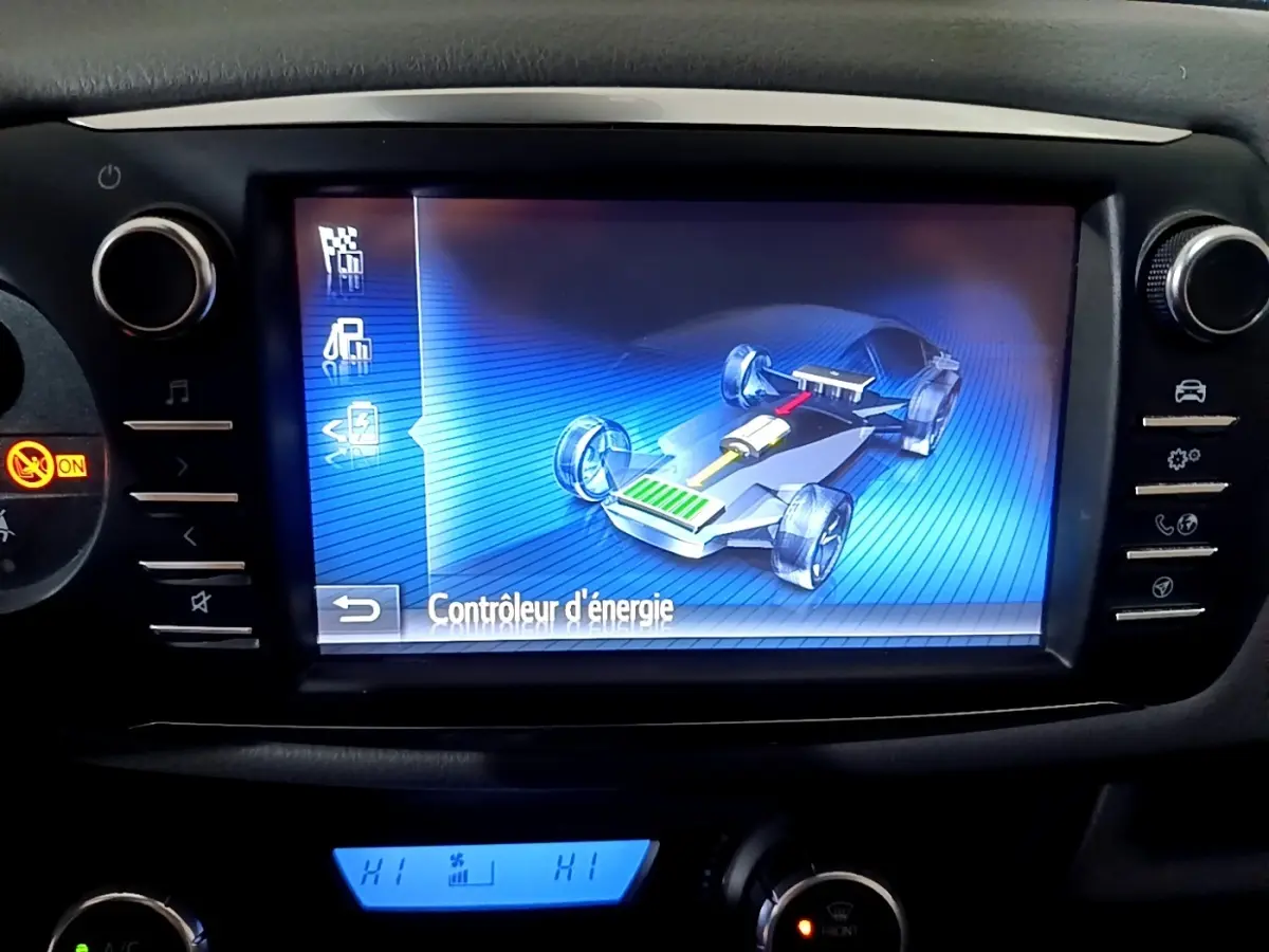 Écran tactile central montrant le contrôle d'énergie hybride sur Toyota Yaris 1.5 VVT-i Hybrid, tableau de bord noir.