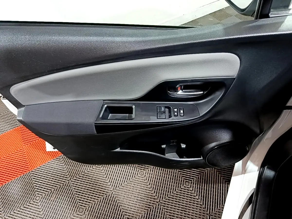 Vue rapprochée de la porte avant gauche blanche de la Toyota Yaris 2019, avec commandes électriques et haut-parleur intégré.