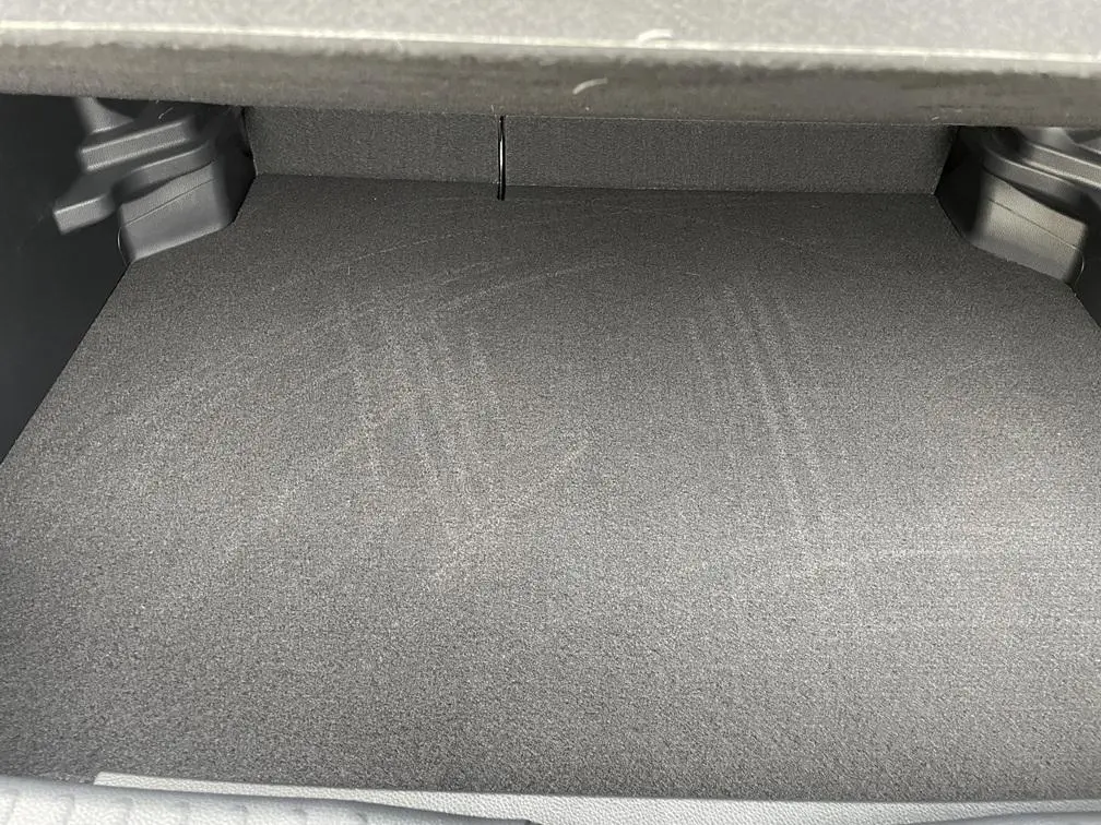 Coffre vide de la Toyota Yaris Cross 1.5 Hybrid 130h Design en gris clair, vue intérieure depuis l'arrière.