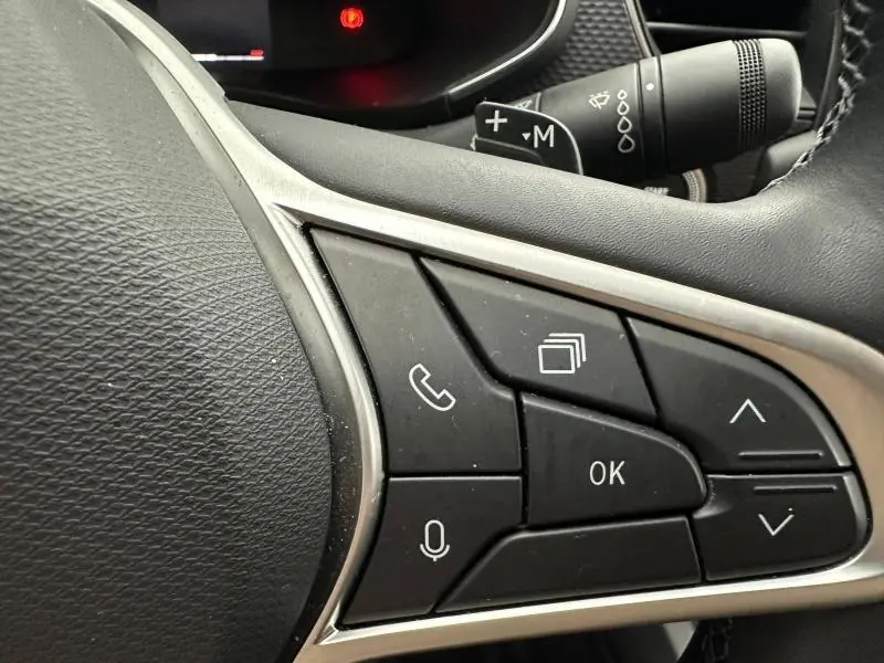 Gros plan sur les commandes multifonctions à droite du volant du Renault Arkana 2025, boutons noirs et cadre argenté.