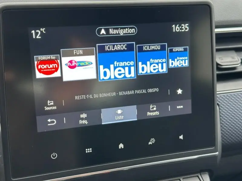 Écran tactile central du Renault Arkana 2025 affichant les stations radio, vue intérieure proche du tableau de bord.
