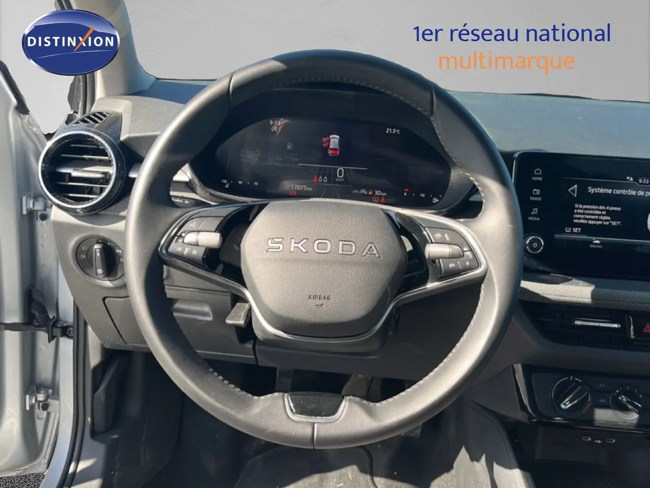 Vue intérieure centrée sur le volant SKODA d’une Fabia 2025 gris argent avec tableau de bord numérique et écran tactile.