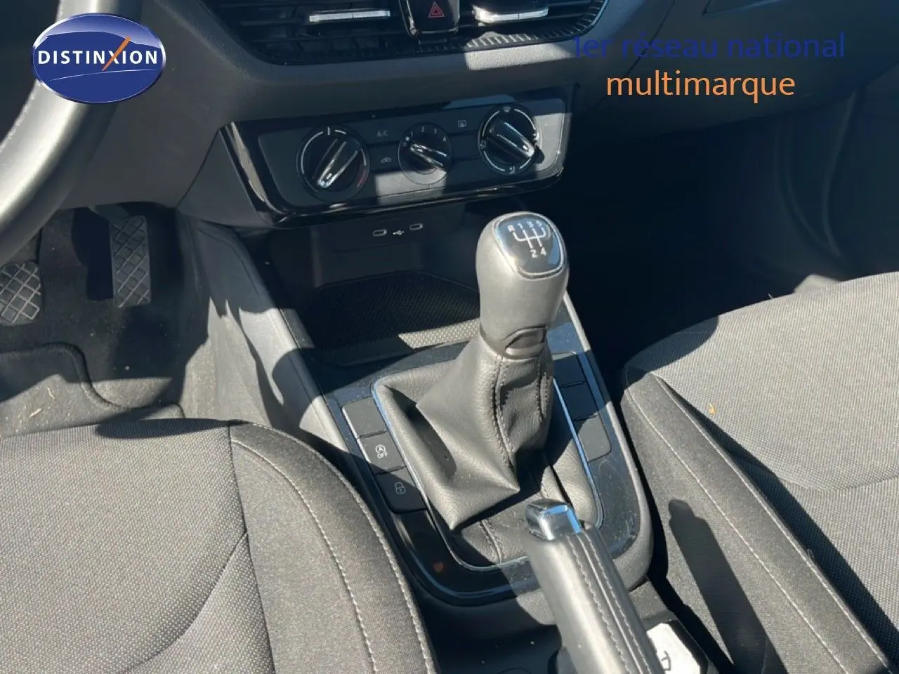 Vue intérieure centrée sur la console centrale et levier de vitesse manuel d'une Skoda Fabia 2025 en tissu gris.