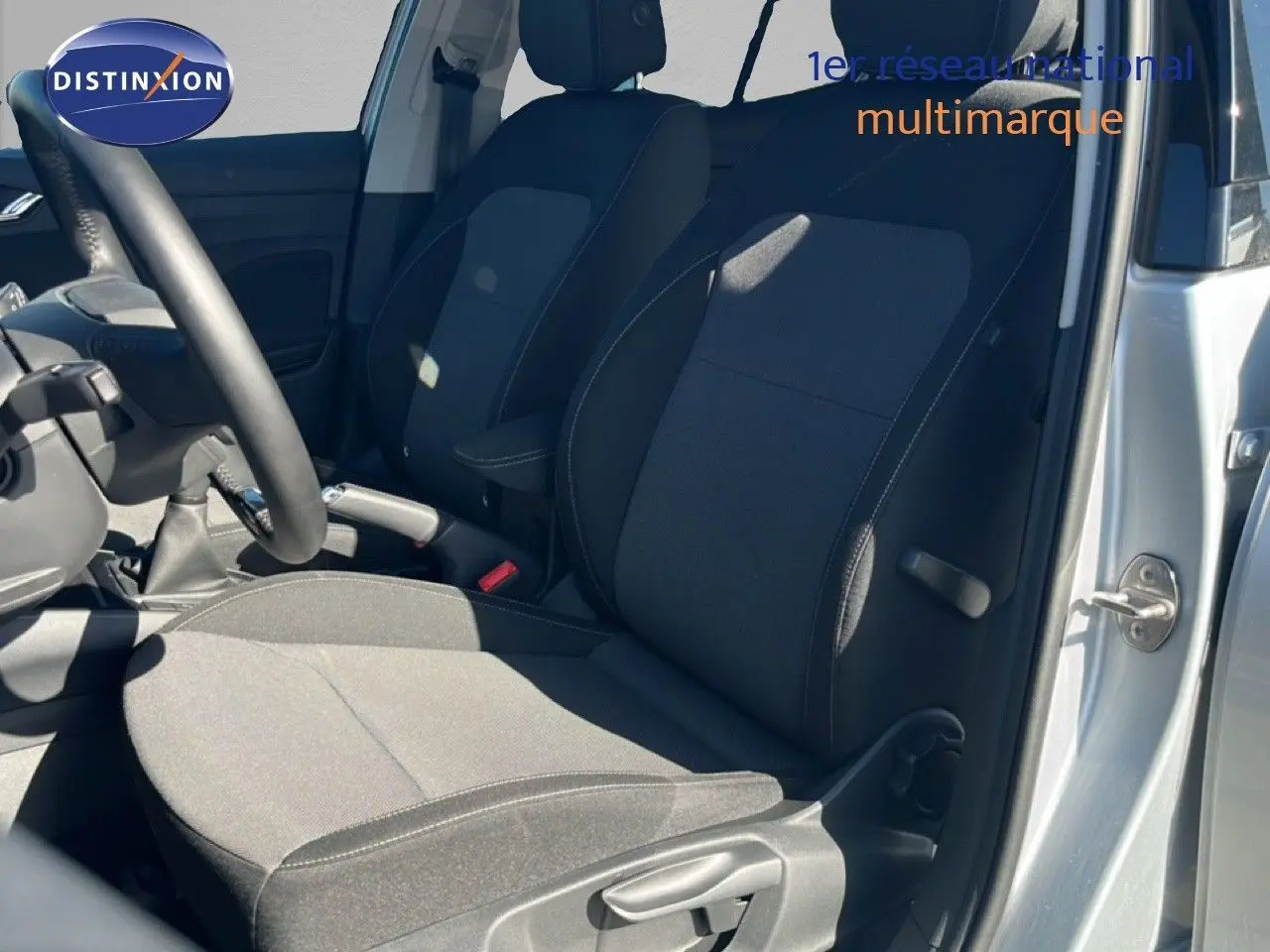 Vue intérieure côté conducteur de la Skoda Fabia 2025 en Reflex Silver, sièges tissu gris foncé avec surpiqûres contrastées.