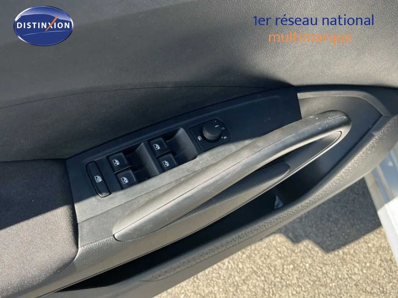 Gros plan sur la commande des vitres électriques côté conducteur d'une Skoda Fabia 2025 couleur argent Reflex Silver Metal.