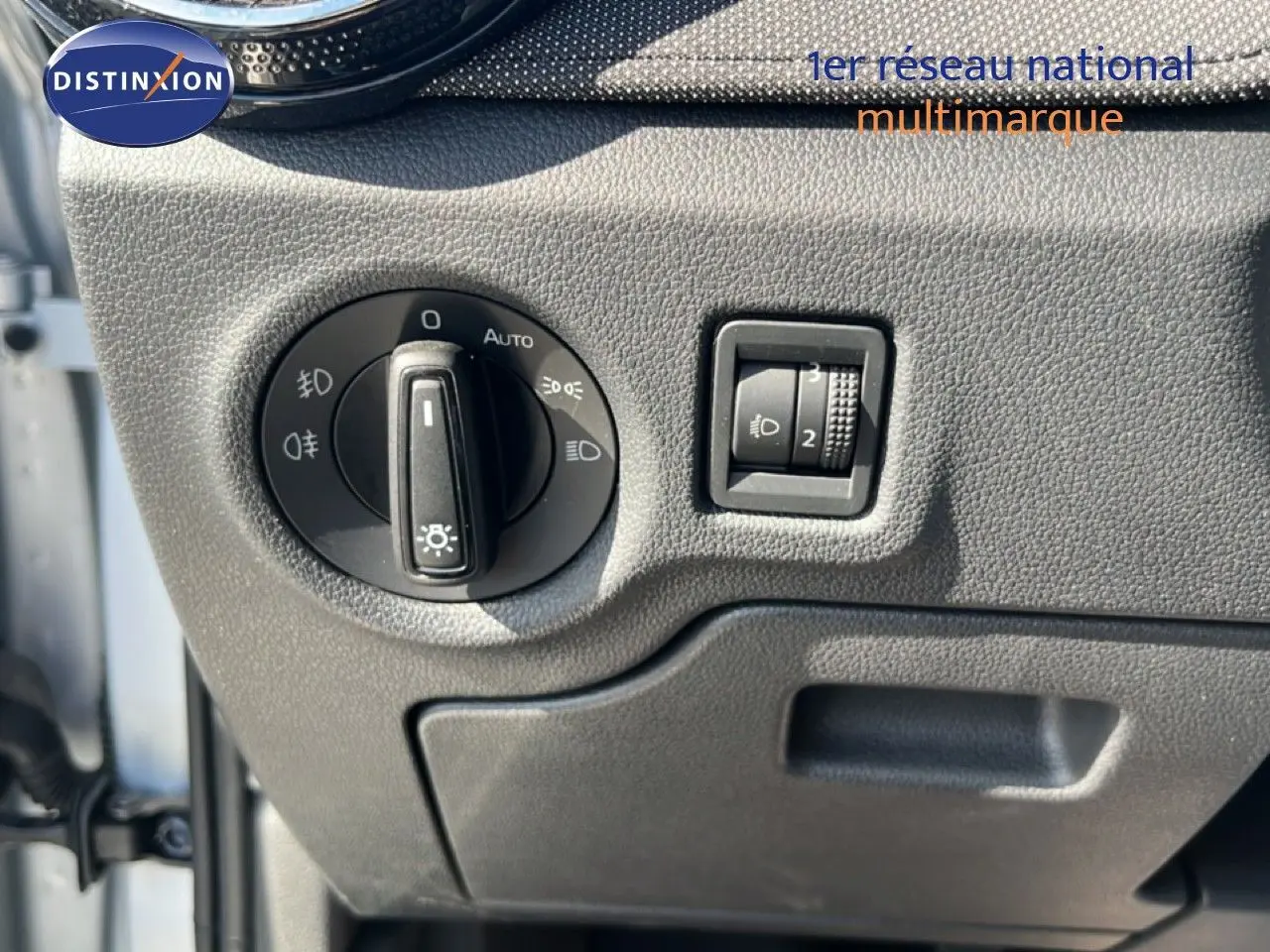Détail du panneau de commande des phares sur la gauche du tableau de bord gris noir d'une Skoda Fabia 2025 Reflex Silver.