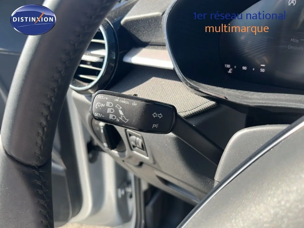Gros plan sur la commande de régulateur de vitesse à gauche du volant d’une Skoda Fabia 2025 gris argent Reflex Silver.