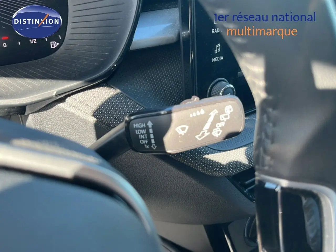 Gros plan sur la commande d’essuie-glace à gauche du volant dans l’habitacle d’une Skoda Fabia gris argent 2025.