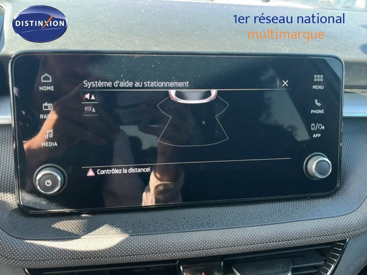 Écran tactile du système d'aide au stationnement de la Skoda Fabia 2025 en gros plan, tableau de bord noir.