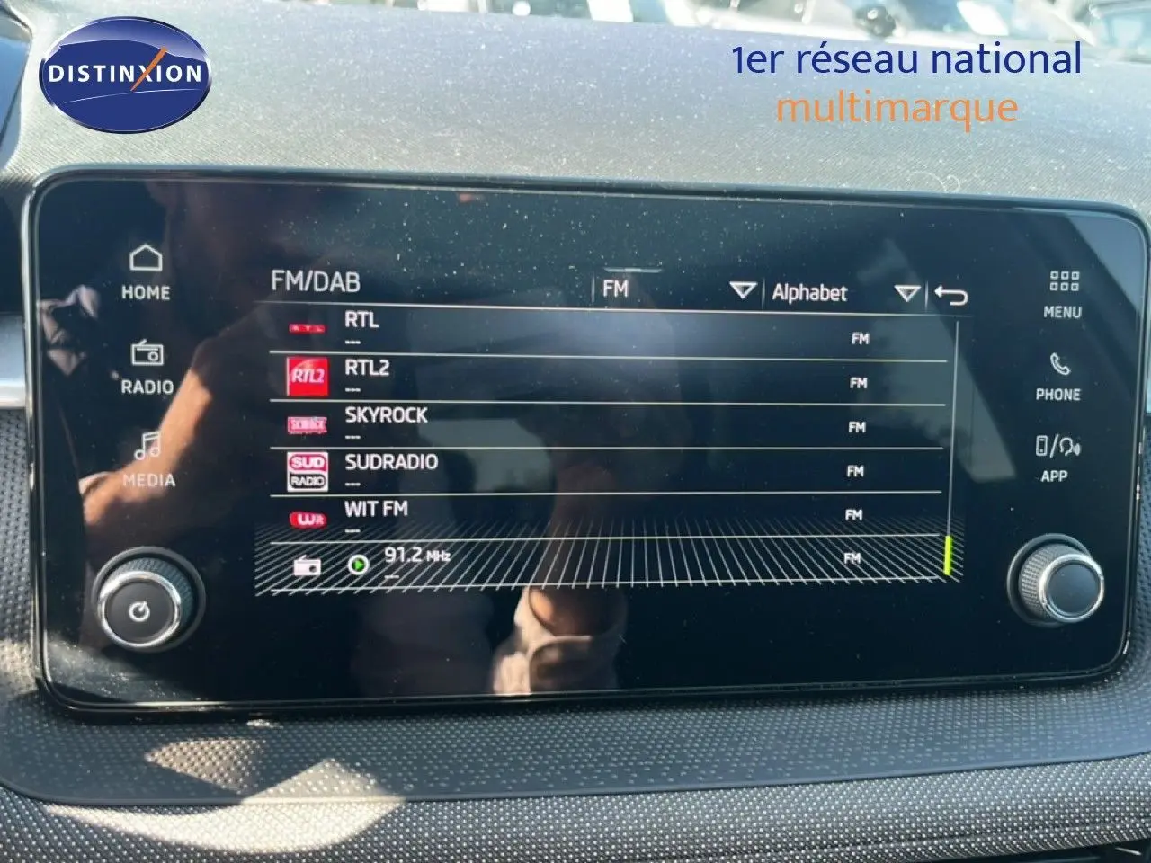 Écran tactile central de la Skoda Fabia 2025 affichant les stations radio FM, avec commandes physiques sur les côtés.