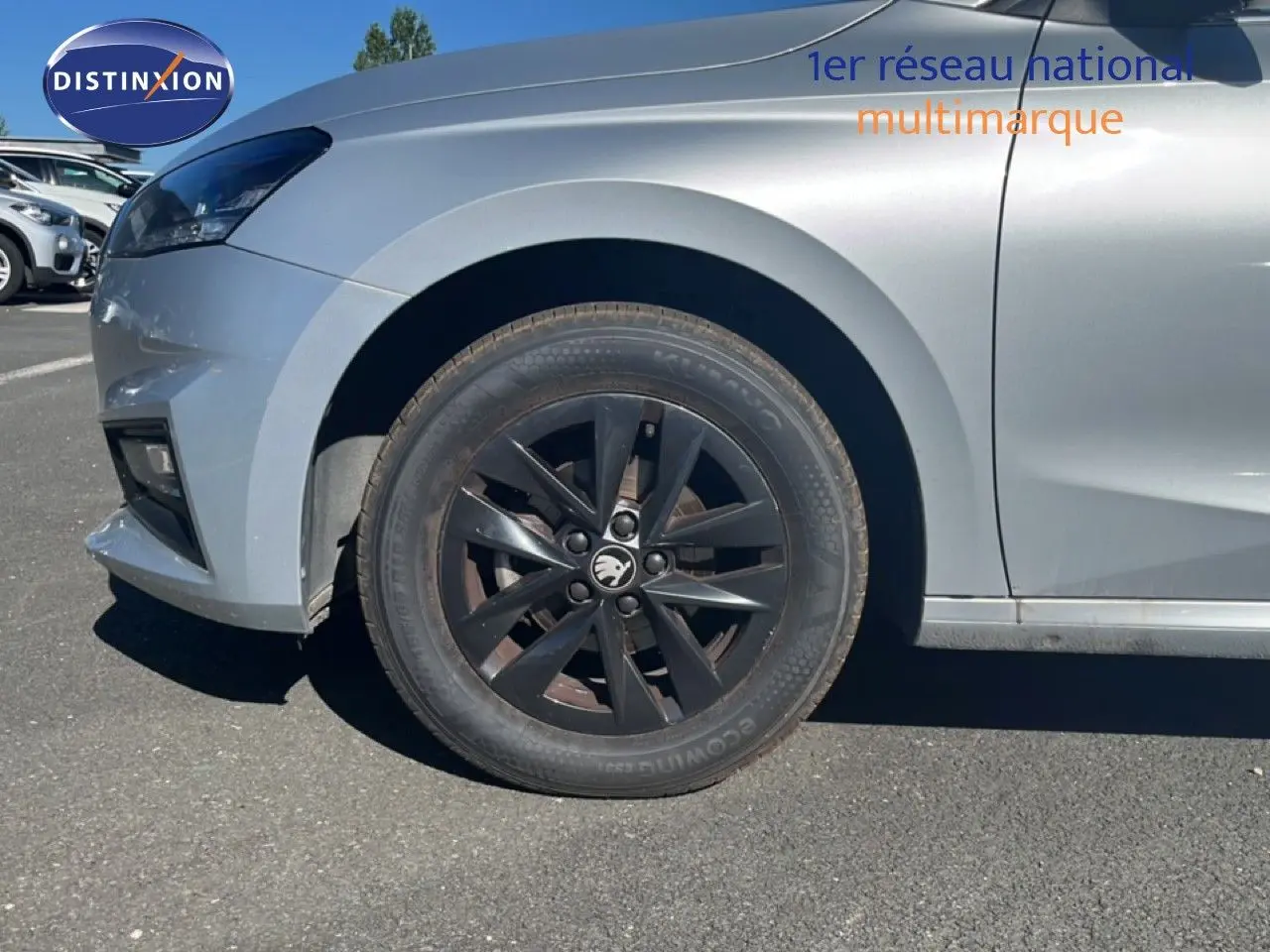 Gros plan sur la roue avant gauche noire d'une Skoda Fabia 2025 en Reflex Silver Metal, avec jante noire distinctive.