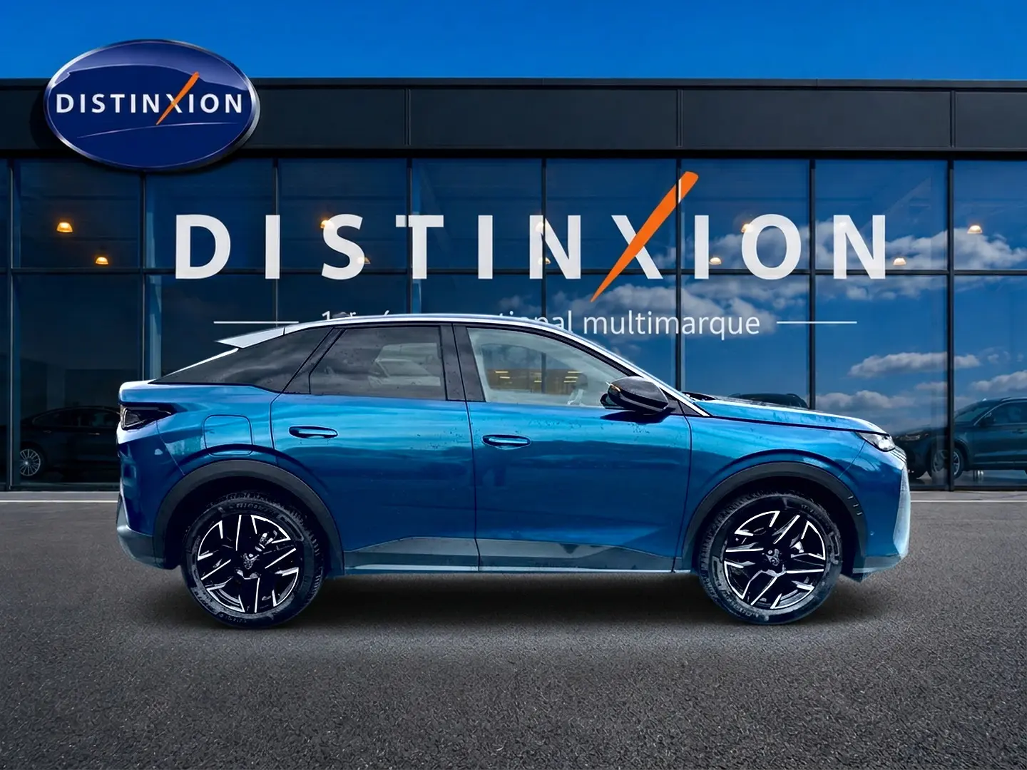 Profil côté gauche du Peugeot 3008 bleu 2025 avec jantes alliage noires et toit noir devant une vitrine Distinxion.