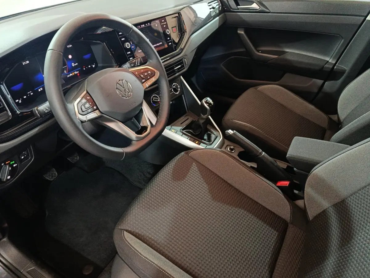 Vue intérieure côté conducteur du Volkswagen Polo 1.0 TSI 95 Life Plus avec volant cuir, tableau de bord digital et boîte manuelle.