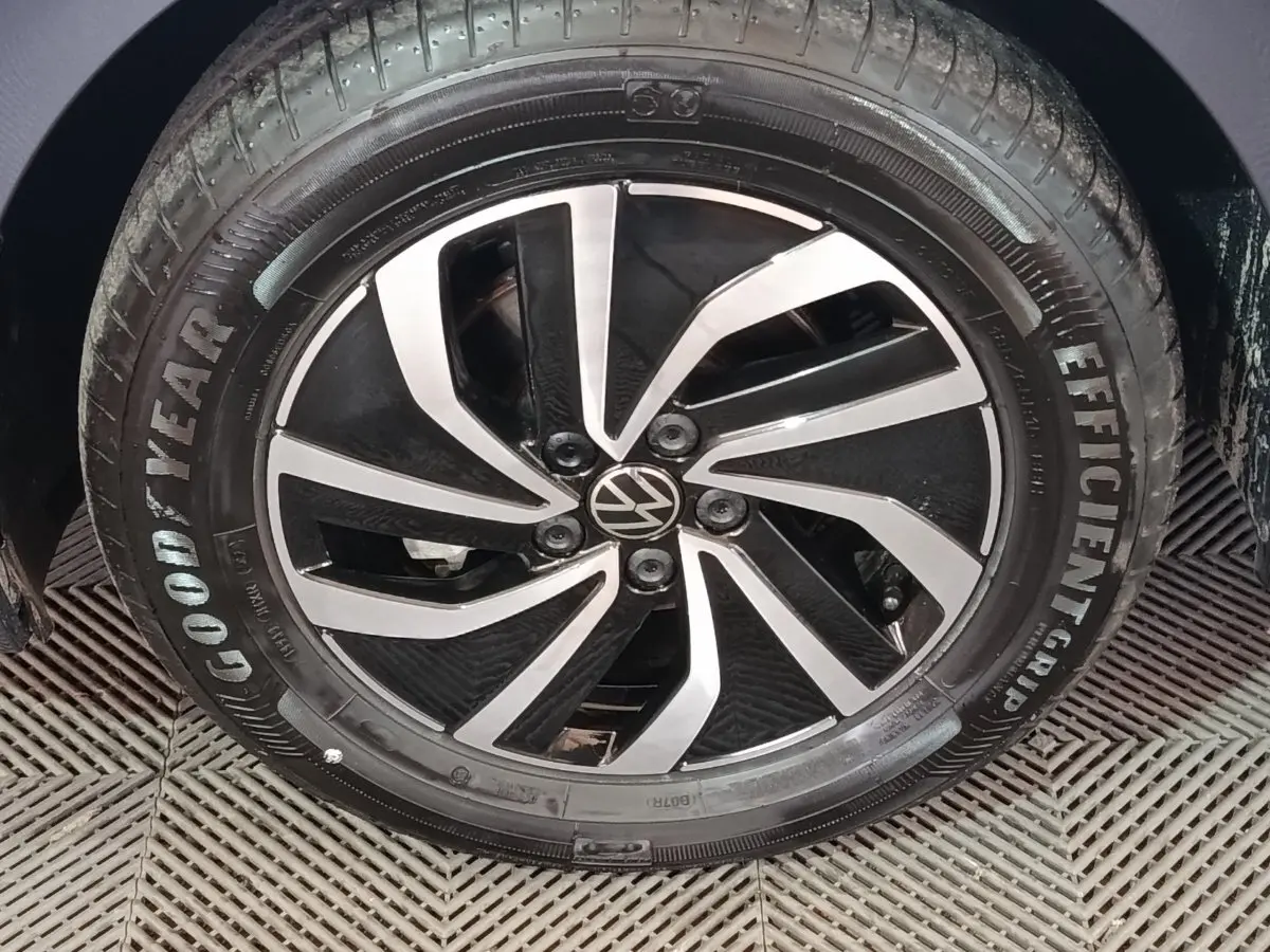 Gros plan sur la jante alliage noire et argentée d'une Volkswagen Polo gris foncé, avec pneu Goodyear visible.
