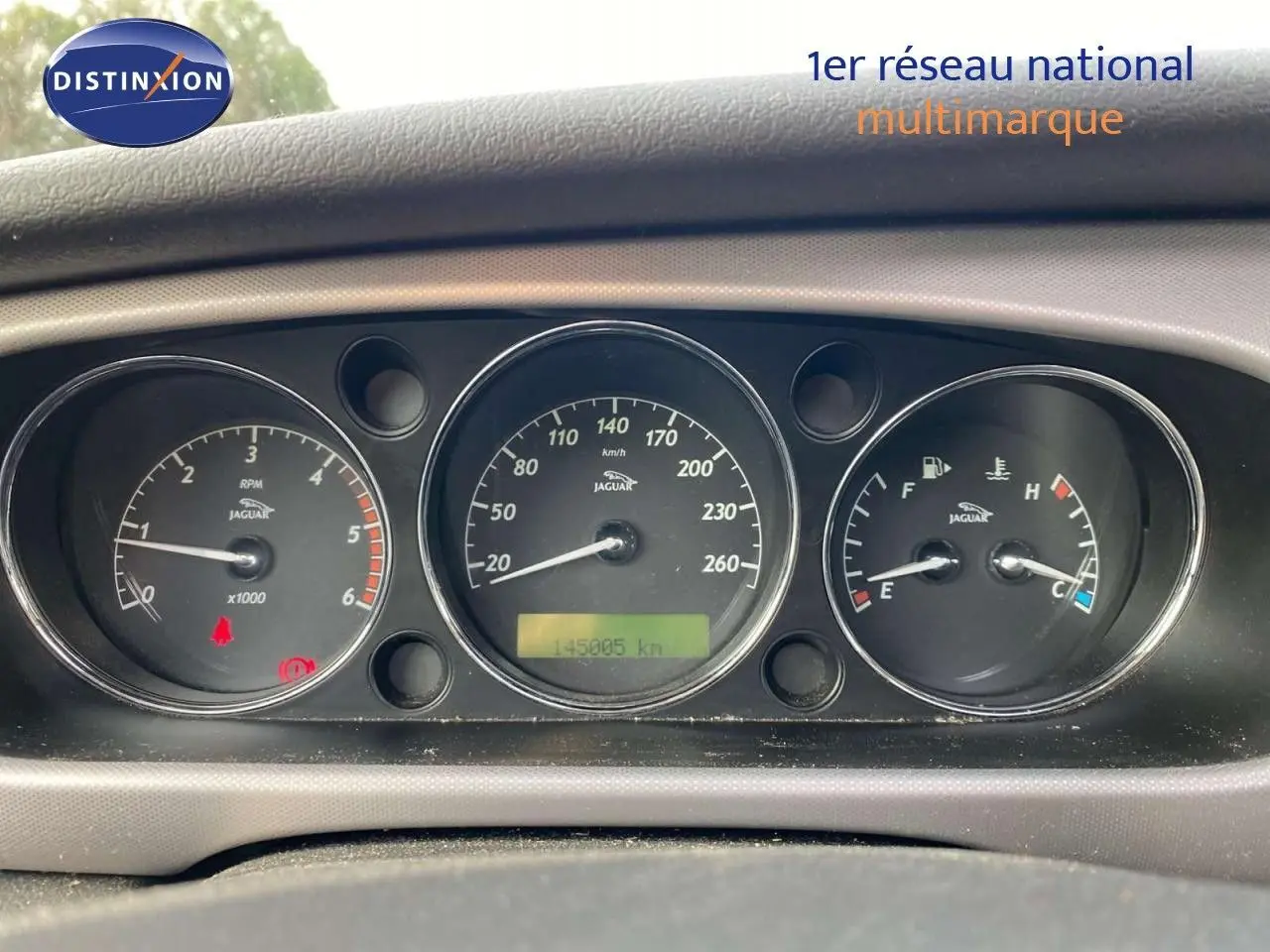 Gros plan sur le tableau de bord noir de la Jaguar XJ6 2.7 V6 Biturbo, affichant compte-tours, vitesse et jauges.