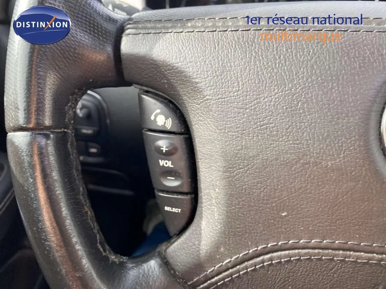 Gros plan sur le volant en cuir noir avec commandes audio intégrées de la Jaguar XJ6 2.7 V6 Biturbo Executive 2006.